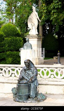 Bronzestatue der sitzenden alten Frau Verkauf gerösteten Kastanien A Steinstatue ein Brunnen und Bronze Büste Saint Mary Bridge Burgos Kastilien und Leon Spanien Stockfoto