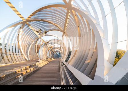 Perspektive Innengang der spiralförmigen kegelförmigen Arganzuela Brücke mit Interne Metall verflochten Spiralen Kreuzung diagonal in Sonnenuntergang Zeit in Madrid Stockfoto