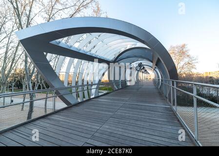 Perspektive Innengang der spiralförmigen kegelförmigen Arganzuela Brücke mit Interne Metall verflochten Spiralen Kreuzung diagonal in Sonnenuntergang Zeit in Madrid Stockfoto