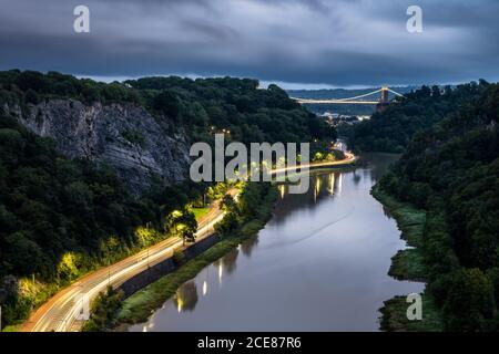 Der Verkehr hinterlässt in der Abenddämmerung auf der A4 Portway Road unter der Clifton Suspension Bridge in Bristol's River Avon Gorge. Stockfoto