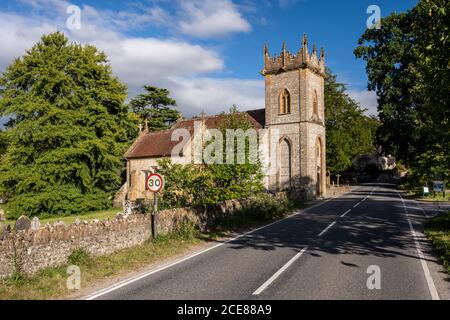 Die Sonne scheint auf dem traditionellen gotischen Turm der St. Andrew's Church an der A352 Straße im Dorf Minterne Magna in Dorset Cerne Valley. Stockfoto
