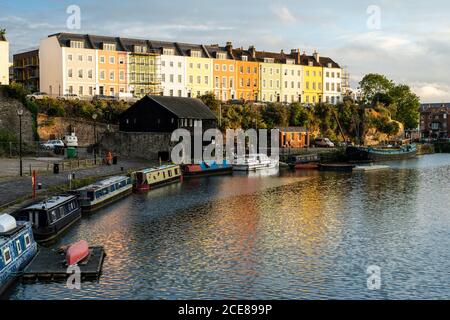 Die Abendsonne scheint auf den farbenfrohen Reihenhäusern der Redcliffe Parade über den Kais des schwimmenden Hafens von Bristol. Stockfoto