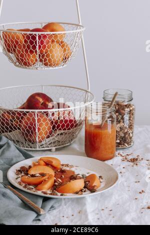 Schale mit gesundem Müsli mit Joghurt und frischem Obst auf Tabelle Stockfoto