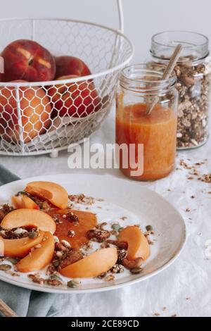 Schale mit gesundem Müsli mit Joghurt und frischem Obst auf Tabelle Stockfoto