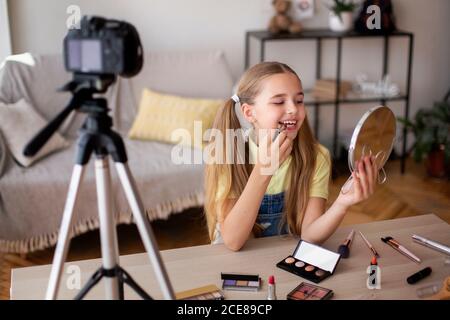 Lächelndes Mädchen Anwendung Make-Up, Aufnahme Ihrer Schönheit Blog Stockfoto