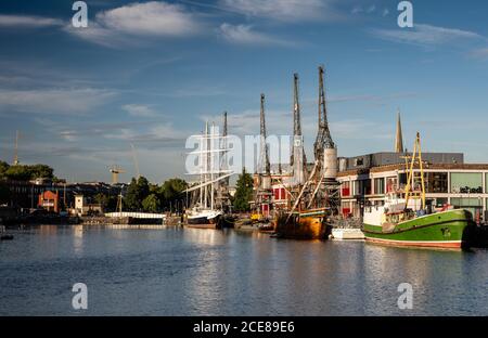 Die Abendsonne scheint auf historischen Schiffen und Booten, die vor dem M Shed Museum auf der erneuerten Hafenseite von Bristol festgemacht sind. Stockfoto