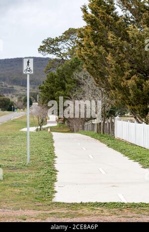 Ein gemeinsamer Fahrrad- und Fußgängerweg aus Beton in der ländlichen Stadt Collector nahe der ACT-Grenze in New South Wales, Australien Stockfoto