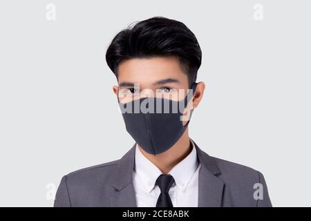 Portrait junge asiatische Geschäftsmann in Anzug tragen Gesichtsmaske für schützende covid-19 isoliert auf weißem Hintergrund, medizinische Maske und Gesundheit, Auswirkungen ein Stockfoto