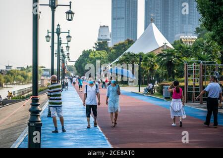 Wuhan China , 30 August 2020 : Chinesen tragen chirurgische Gesichtsmasken auf Yangtze Uferpromenade an heißen sonnigen Sommer 2020 Tag in Wuhan Hubei C. Stockfoto