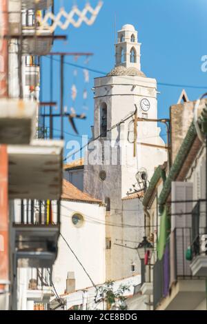 Außenansicht der alten Santa Maria Kirche mit weißem Stein Wände gegen blau bewölkten Himmel in sonnigen Tag in Cadaques Stadt in Spanien Stockfoto