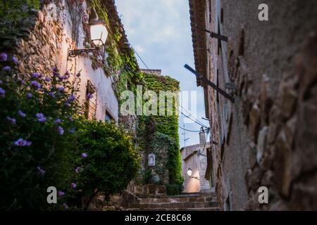 Steinmauer des alten Gebäudes auf der alten Straße von Tossa De Mar Gemeinde in Spanien im Sommerabend Stockfoto