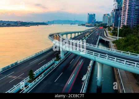 Von oben der modernen erhöhten Autobahnkreuzung mit Markierungslinien Ohne Autos, die entlang der Küste in Xiame Stadt in China am Abend Stockfoto