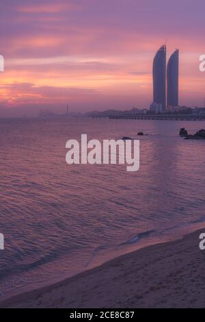 Silhouetten moderner Wolkenkratzer am Meer der Stadt Xiamen Gegen bunten Sonnenuntergang Himmel in der Abendzeit in China Stockfoto