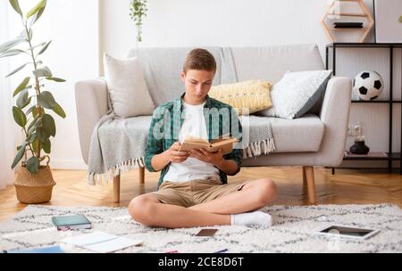 Teenager Buch zu Hause lesen, Hausaufgaben machen Stockfoto