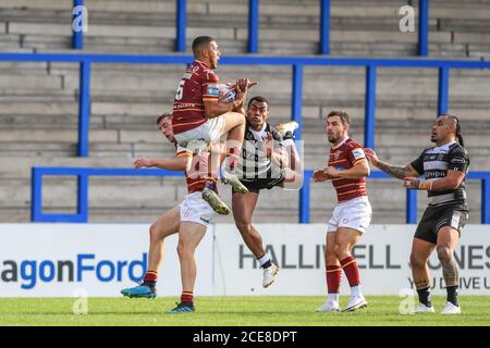 Darnell Mclntosh (5) von Huddersfield Giants fängt den hohen Ball Wie Ratu Naulago (33) vom Hull FC in die Tiefe taucht Der Ball Stockfoto