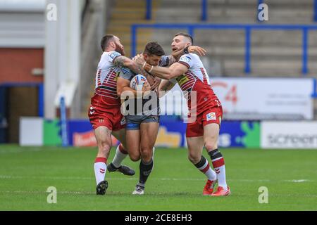 Alex Foster (17) von Castleford Tigers wird von Jake angegangen Bibby (23) von Wigan Warriors und Jackson Hastings (31) von Wigan Warriors Stockfoto