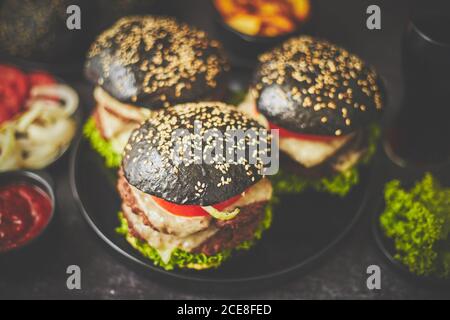 Schwarze Doppel-Burger mit Gemüse und Käse Stockfoto