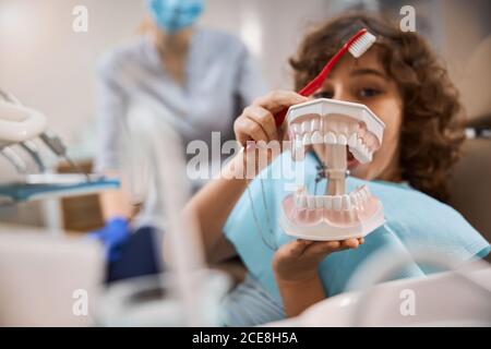 Neugieriges Kind erforscht Kiefer Requisiten in der Zahnklinik Stockfoto