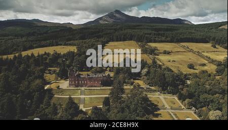 Schottlands Landschaftsaufnahme: Berge, altes Brodick Castle mit Goatfell Mount. Epische Szenerie schottischer Wahrzeichen. Wunderbare Wälder und Täler bei Sommer Tag weiten Blick Stockfoto