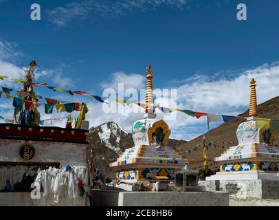 Buddhistische Stupas mit Gebetsfahnen über schneebedeckten Himalaya unter blauem Himmel zwischen Manali und Kaza, Himachal Pradesh, Indien. Stockfoto