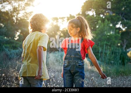 Zehnjährige Freunde und Jungen, die auf dem Land spazieren gehen Ein sonniger Sommertag in T-Shirts und Jeans