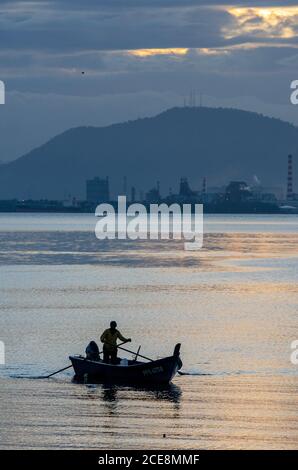 Georgetown, Penang/Malaysia - 27 2016. Februar: Ein Mann rudern das Boot in der Straße von Malacca. Hintergrund ist das Festland Seberang Perai. Stockfoto