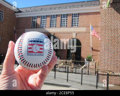 Cooperstown, NY / USA - 3. Juni 2019: Ein Baseball mit dem Logo der National Baseball Hall of Fame vor dem Hall Museum Stockfoto