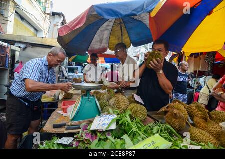 Georgetown, Penang/Malaysia - Jun 18 2016: Ein Mann riecht den Durian, um zu bestimmen, welcher gekauft werden soll. Stockfoto