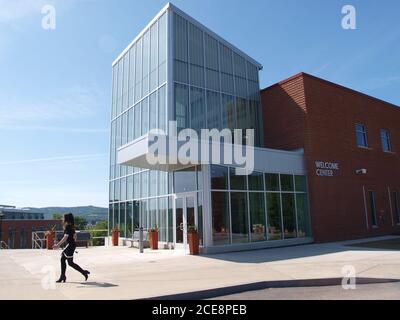 Oneonta, NY / USA - 15. Juli 2019: Eine Frau geht am neuen Welcome Center am State University of New York College auf dem Oneonta Campus vorbei. Stockfoto