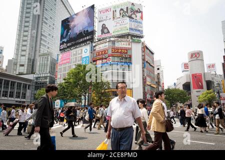 Tokio, Japan - Shibuya Scramble Crossing. Viele Menschen überqueren die Straße in einem der belebtesten Gegenden. Überfüllt und voller Werbetafeln. Stockfoto