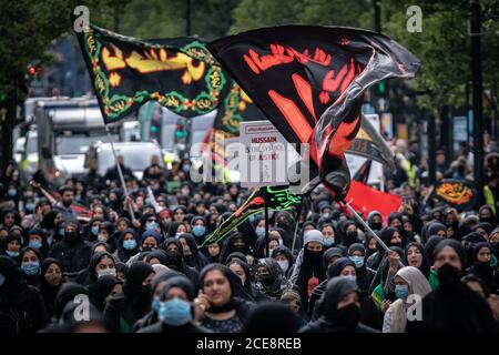 Aschura 2020. Hunderte von britischen Muslimen marschieren die Oxford Street hinunter zur jährlichen Arbaeen-Prozession zu Ehren und zur Feier von Husain ibn Ali, dem Enkel des Propheten Muhammed. Im Westen ist Ashura am besten für ein Ritual der Selbstgeißelung bekannt, das nur von einer Minderheit von Muslimen beobachtet wird. London, Großbritannien. Stockfoto