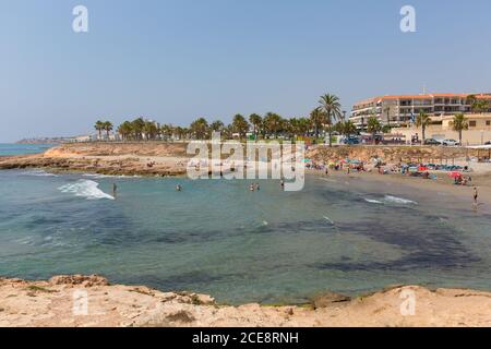 Playa Cala Mosca Strand Punta Prima Spanien mit Menschen auf Der Strand bei schönem Wetter Stockfoto