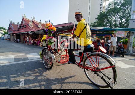 Georgetown, Penang/Malaysia - Jul 03 2016: Rikscha-Fahrer auf der Straße in der Nähe des Tempels der Göttin der Barmherzigkeit. Stockfoto