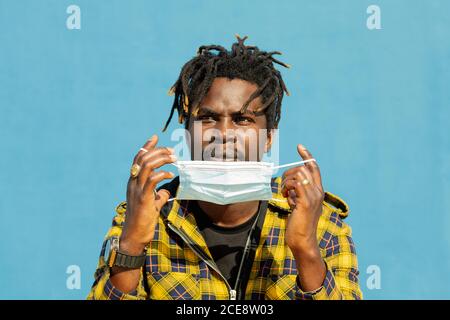 Attraktiver junger afrikanischer Mann mit Schutzmaske, Lifestyle-Konzept und Covid-Schutz Stockfoto