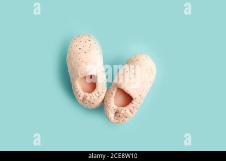 Paar niedliche rosa Fuß Hausschuhe mit Sternen auf blauem Hintergrund. Speicherplatz kopieren. Draufsicht. Stockfoto
