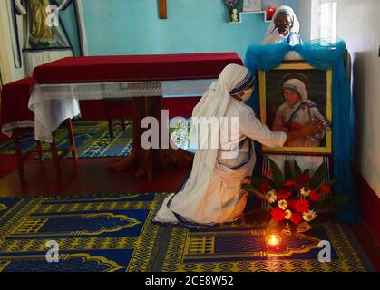 Katholische Nonnen aus Nirmala Shishu Bhavan reinigen das Foto von Mutter Teresa und bereiten den Ort zum Gebet vor, um an den 110. Geburtstag von Mutter Teresa zu erinnern. Agartala, Tripura, Indien. Stockfoto