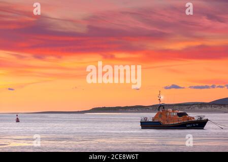 Nach Sonnenuntergang wird der Himmel rosa hinter RNLB 'mullie Hunt', dem Allwetter-Rettungsboot der RNLI Tamar-Klasse an ihrem Liegeplatz auf dem Torridge in Appledo Stockfoto