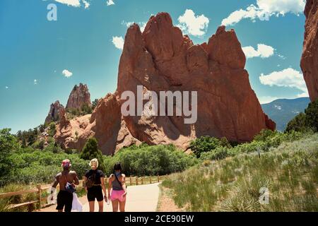 Rückansicht einer Gruppe von multiethnischen Reisenden, die den Weg entlang gehen Und genießen Sie einen herrlichen Blick auf die Felsen im Garten der Götter in Colorado Stockfoto