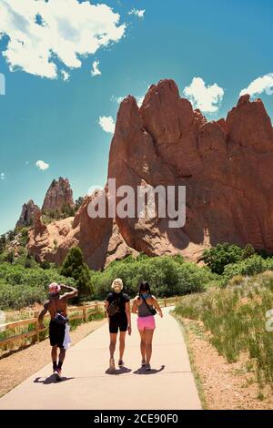 Rückansicht einer Gruppe von multiethnischen Reisenden, die den Weg entlang gehen Und genießen Sie einen herrlichen Blick auf die Felsen im Garten der Götter in Colorado Stockfoto