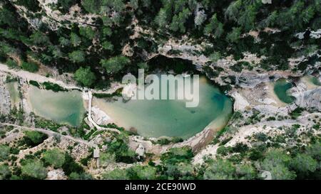 Erstaunliche Drohne Ansicht der malerischen Landschaft des Teiches mit Türkis Wasser umgeben von grünen Wäldern Stockfoto