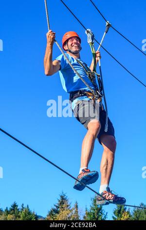 Man Balancieren auf hohem Seil im Hochseilgarten Stockfoto