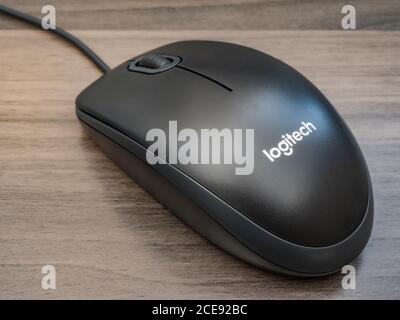 Nahaufnahme einer grundlegenden Logitech-Computermaus (Eingabegerät), mit Scrollrad, in grau/grau, auf einem Schreibtisch. Stockfoto