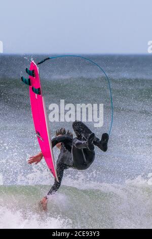 Spektakuläre Action, als ein Surfer auf einer Welle bei Fistral in Newquay in Cornwall auswischt. Stockfoto