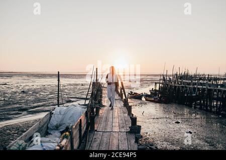 Frau auf schäbigen hölzernen Pier im Meer Stockfoto