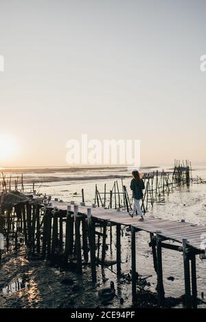 Frau auf schäbigen hölzernen Pier im Meer Stockfoto
