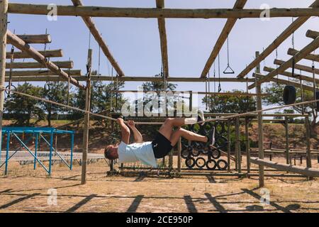 Männliche Fitness-Trainer hängen kopfüber auf einem Seil an Ein Boot Camp Stockfoto