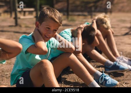 Gruppe von Jungen, die Sit-ups in einem Bootcamp durchführen Stockfoto