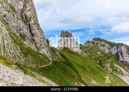 Wanderer auf dem steilen Weg zum majestätischen Schaefler Gipfel im Alpsteingebirge rund um die Aescher Klippe in Appenzell, Schweiz Stockfoto