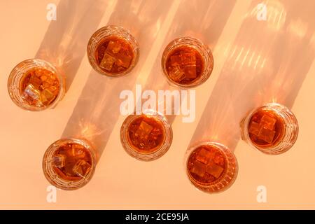 Viele Gläser kalten Whiskys serviert in Felsen auf beigefarbenem Hintergrund. Stockfoto
