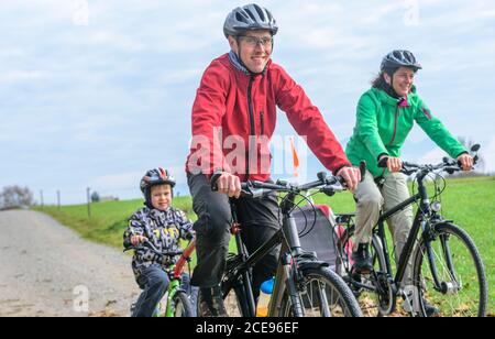 Junge Familie hat viel Spaß beim Radfahren in Herbstliche Natur Stockfoto